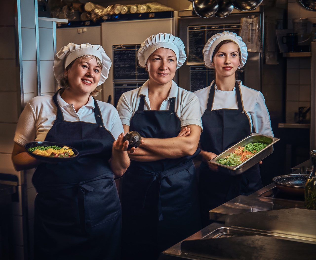 cooking team standing next to a table with chopped vegetables at restaurant s kitchen.jpg