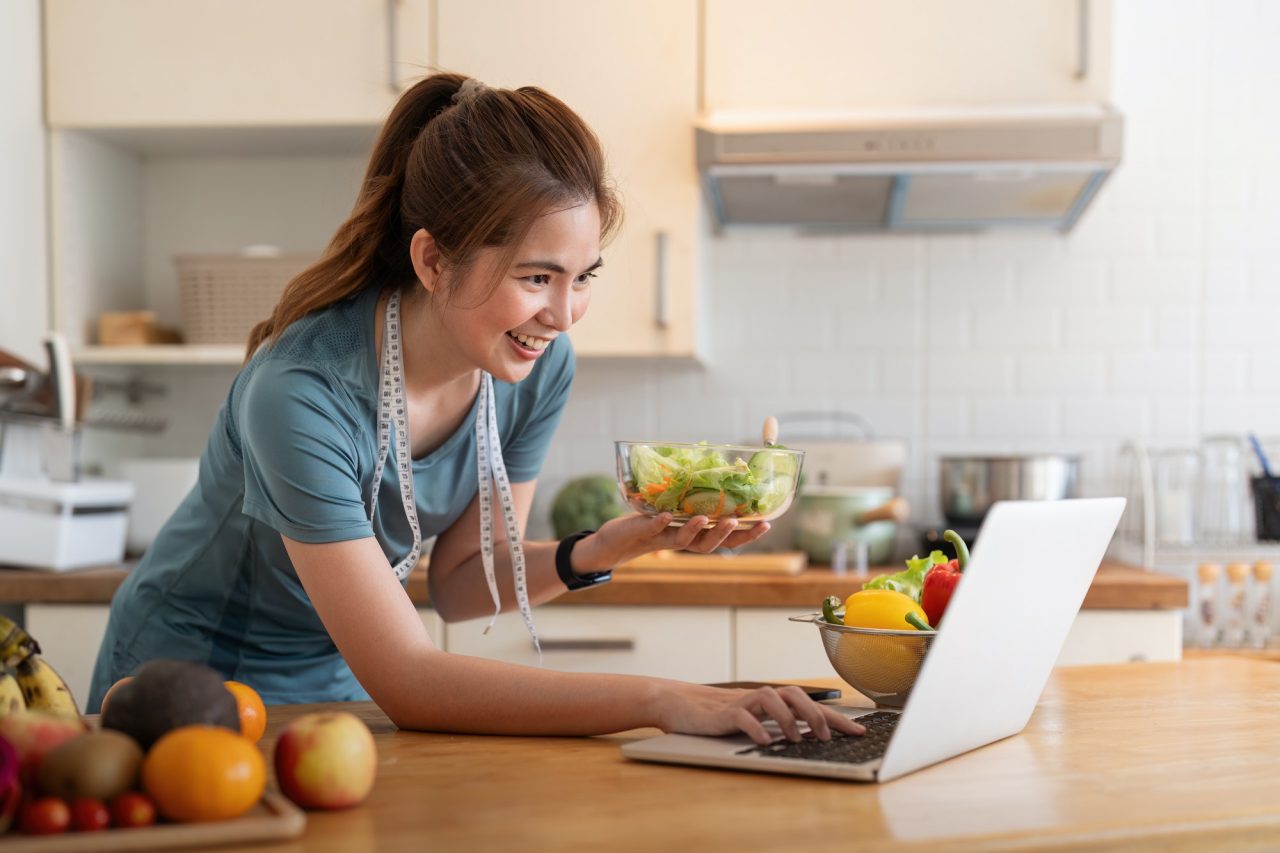 young woman eat healthy food sitting in the kitchen.jpg